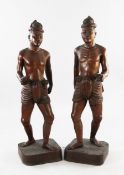 A pair of large Balinese teak figures of native men, first half 20th century, each on naturalistic