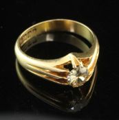 A George V 18ct gold and claw set solitaire diamond ring, with pierced shoulders, the round cut