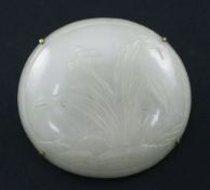 A Chinese pale celadon jade oval plaque, 18th / 19th century, carved in relief with a flowering