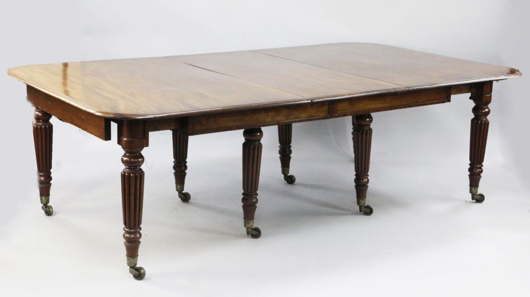 A 19th century mahogany extending dining table, with three extra leaves, on tapering reeded legs and
