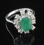 An 18ct white gold, emerald and diamond cluster ring, size N.