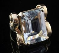 A 1940's 14ct gold and aquamarine ring, with ornate scroll setting and set with emerald cut stone,