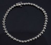 A 9ct white gold and diamond line bracelet, set with forty nine round brilliant cut champagne