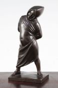 A small Italian patinated bronze of a figure standing in a hooded cloak, with arms behind his