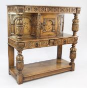 A 17th century style inlaid oak court cupboard, with carved cup and cover uprights and open space