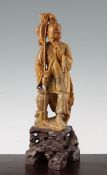 A Chinese soapstone figure of a fisherman, early 20th century, the standing figure of the
