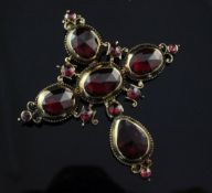 A Victorian gold and foil backed garnet cruciform pendant, set with facetted oval and round cut