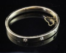 A gold and gypsy set three stone diamond hinged bangle, unmarked, gross weight 12 grams.