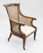A George IV mahogany tub shape bergere armchair, with scrolling back rail, stiff leaf carved arms,