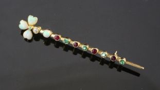 An early 20th century gold, white opal, diamond emerald and ruby bar brooch, the terminal set with