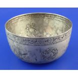 An early 20th century Burmese? silver circular bowl, with embossed foliate border and decorated with