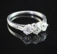 A platinum and three stone diamond ring, set with round brilliant cut stones and diamond set