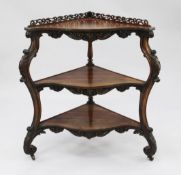 A Victorian rosewood three tier corner whatnot, with pierced gallery and scroll carved uprights,