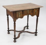 An 18th century oak lowboy, with three frieze drawers, on tapering turned supports and shaped X