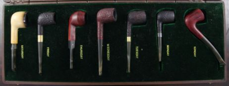 A collection of six Alfred Dunhill smoking pipes, two with gold bands, together with a Peterson's