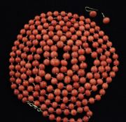 A single strand coral bead necklace, with yellow metal clasp, 57in, together with a pair of coral