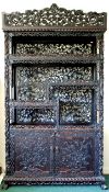 A Chinese black lacquered rosewood cabinet, late 19th century, carved in relief and openwork with