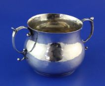 An early Charles II silver porringer, with prick dot initials and scroll handles, the base with