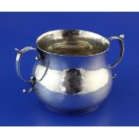 An early Charles II silver porringer, with prick dot initials and scroll handles, the base with