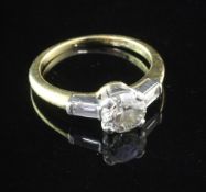 An 18ct gold and platinum single stone diamond ring with baguette cut diamond set shoulders, with