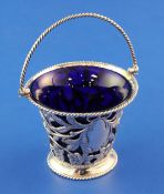 A late Victorian silver cream pail, with pierced foliate decoration, rope twist handle and blue