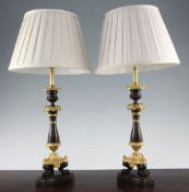 A pair of French bronze and ormolu Empire style table lamps, on a tripartite platform base, with