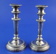 A pair of George III silver candlesticks, with turned tapering stems and engraved armorial, (a.