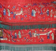 A Chinese embroidered silk red satin panel, early 20th century, woven with a procession of figures