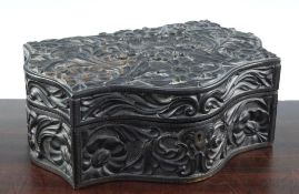 A 19th century serpentine shaped Ceylonese ebonised wood box, relief carved decorated all over