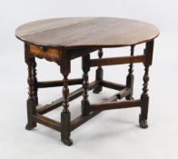 A Queen Anne oval oak gateleg table, with baluster turned uprights and braganza feet, extended W.3ft