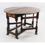 A Queen Anne oval oak gateleg table, with baluster turned uprights and braganza feet, extended W.3ft