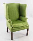 A George III style wingback armchair, upholstered in a green Moray fabric, on moulded square section