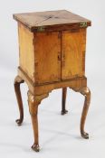 A small 18th century and later padouk wood cabinet on stand, with envelope folding swivel top over