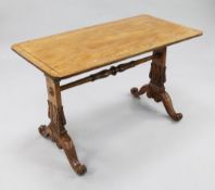 A Victorian satinwood rectangular stretcher table, with stiff leaf carved trestle ends united by