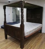 A 17th century carved oak tester bed, with floral scroll carved panelled headboard dated 1613,