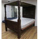 A 17th century carved oak tester bed, with floral scroll carved panelled headboard dated 1613,