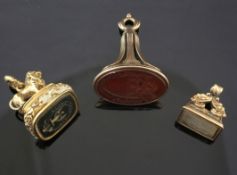 Three Victorian carnelian and gold overlaid seals, including bloodstone with lion surmount, each
