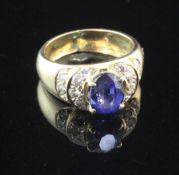 A gold, sapphire and diamond set dress ring, with central oval cut sapphire, flanked by sixteen