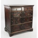 A late 17th century oak chest, of two short and three long drawers, with geometric fronts and