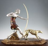 A French Art Deco silvered and painted model of a huntress, with attendant dog, on stepped brown