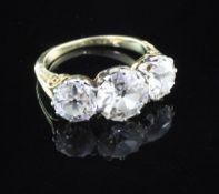 A Victorian style gold three stone diamond ring, with carved shank, the central old cut diamond