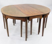 A George III mahogany and satinwood banded extending dining table, with four extra leaves and demi