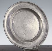 An 18th century pewter dish, decorated with wriggle work, depicting a pelican feeding its young with