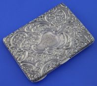 A late Victorian repousse silver card purse, of rectangular form with engraved monogram and