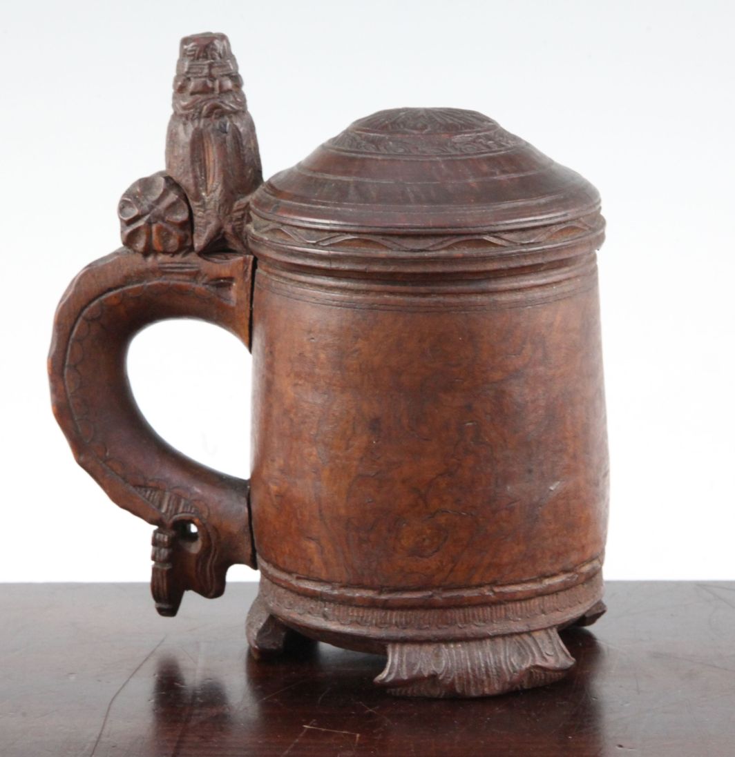 A 19th century Norwegian birch wood peg tankard, with carved thumb piece and domed lid, with