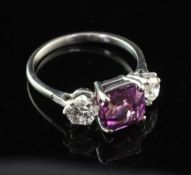 A white gold and three stone purple sapphire and diamond ring, set with square cut sapphire and