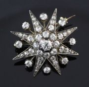 An early 20th century gold and silver, diamond starburst pendant brooch, set with old cut