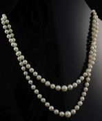 A 1980's double strand graduated cultured pearl necklace, with engraved 9ct gold oval clasp, 21.