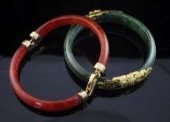 A gold mounted jadeite hinged bangle, with pierced scroll mounts, together with a gold mounted