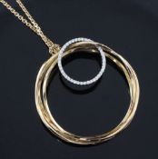 A Greek 18ct gold triple ring pendant by Poniros, with interlinked diamond set smaller ring, signed,